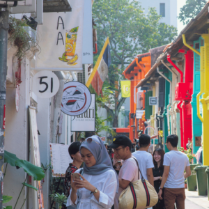 Shoppers navigating through a bustling street in Singapore, seeking out the best deals and practicing effective budgeting hacks.