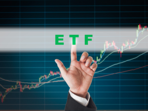 The hand is pointing the word "ETF" with the chart in the background.