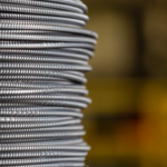 Steel coils representing industrial demand within US equities as Nucor stock approaches record highs driven by strong infrastructure growth