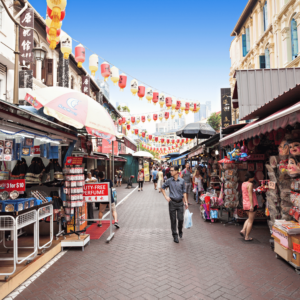 A diligent Singaporean father, keen on maintaining his family's budget, thoughtfully shops at a local market, demonstrating one of the many effective strategies families in Singapore use to manage their expanding financial needs