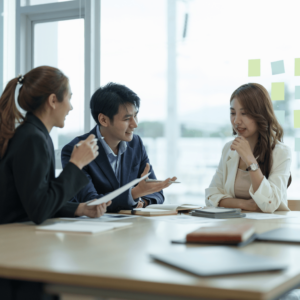 A group of young professionals engaged in a lively discussion in a modern, cozy room, with books and notebooks scattered on the desk. This scene exemplifies collaborative learning and strategic planning, essential components in setting financial goals and mapping the path to prosperity.