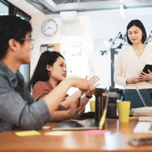 A young couple attentively engaging in a financial planning discussion with their accountant in a well-lit conference room.