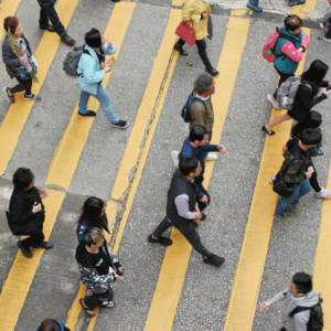 Crowds of individuals navigating a bustling intersection in the heart of Singapore, a testament to the city's vibrant economy and the successful implementation of personal finance best practces.