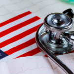 Close-up of a stethoscope on the American flag with ECG lines—capturing the US healthcare sector, policy shifts, and market outlook themes.