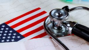 Close-up of a stethoscope on the American flag with ECG lines—capturing the US healthcare sector, policy shifts, and market outlook themes.