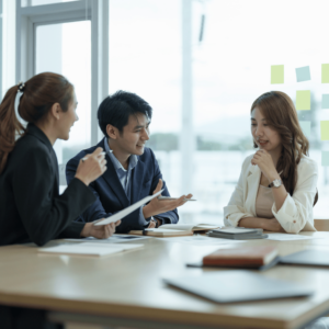 A young couple engaged in a discussion with a professional accountant in a modern office, exploring tax reduction strategies for retirement planning in Singapore.